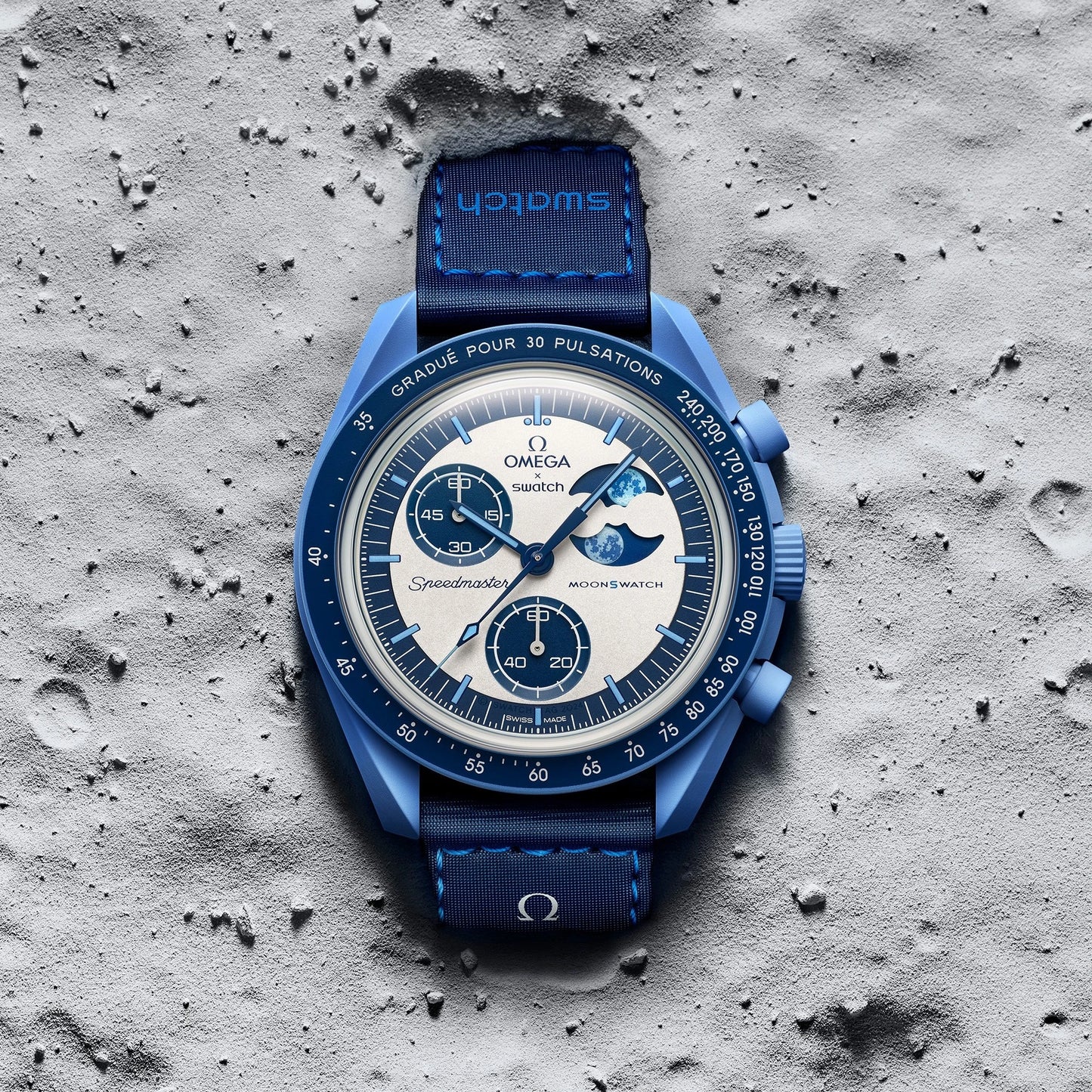 Blue Omega watch on a textured gray surface